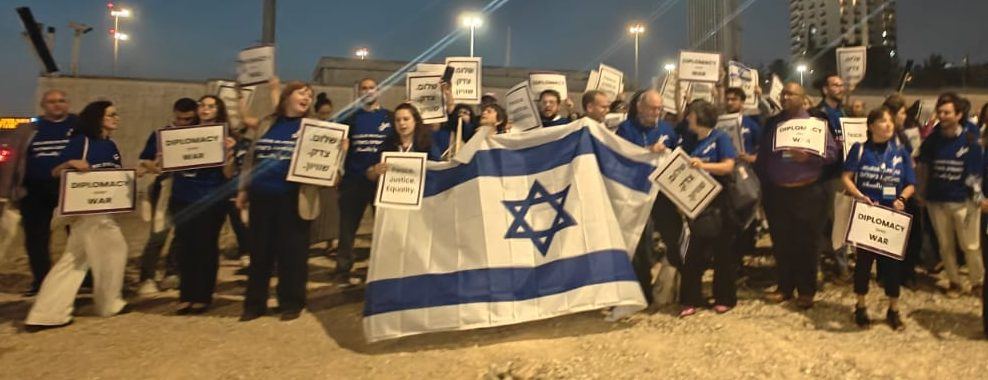 Marcha de la UPZ en Jerusalén con una bandera de Israel y carteles por la diplomacia y la paz