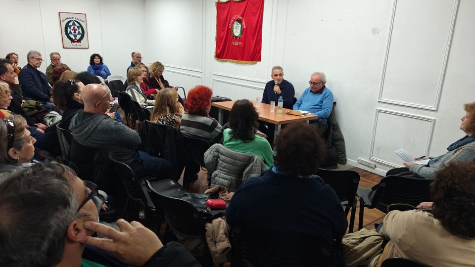 Público sentado frente a la mesa de una charla