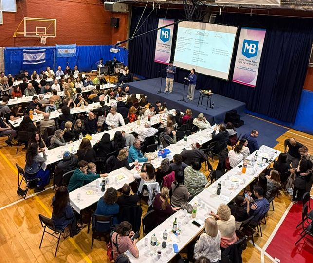 Evento con cientos de personas en mesas largas